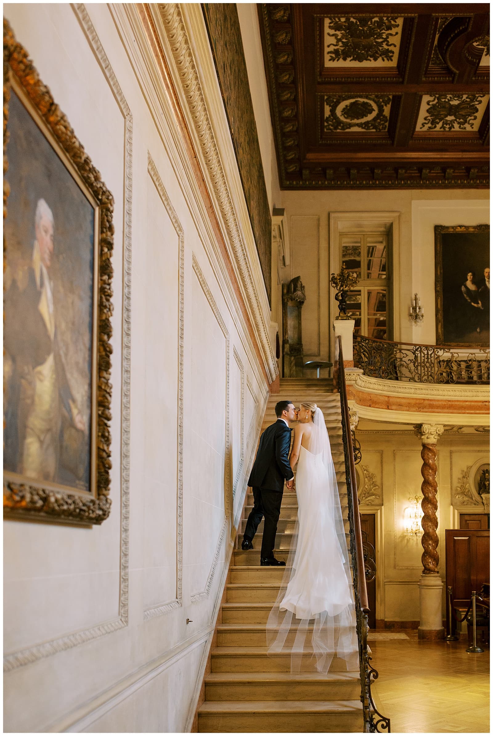Bride and Groom kissing on the steps of the marble staircase in the Larz Anderson House