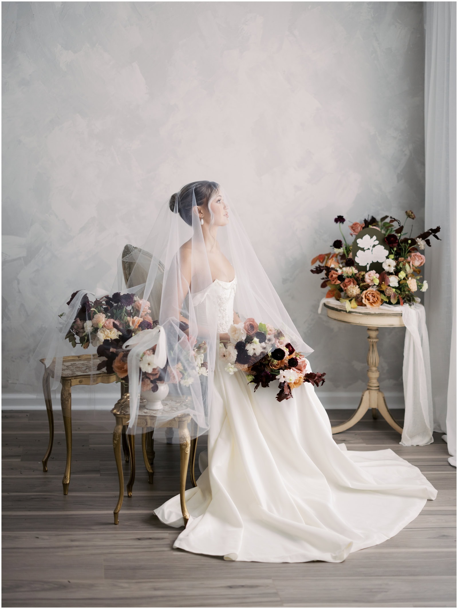 Elegant bridal portrait with a flowing wedding gown and a sheer veil, captured by Danielle Defayette Photography, highlighting fine art wedding photography and bridal portraits.